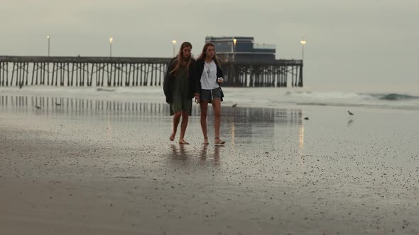 Two people walking on beach early in the morning