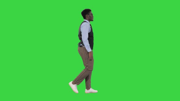 Young African American Business Man in Glasses Walking Confidently on a Green Screen, Chroma Key.