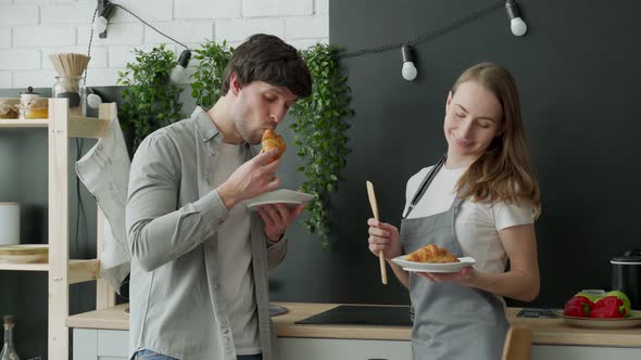 A Happy Young Couple is Having Breakfast in the Kitchen at Home