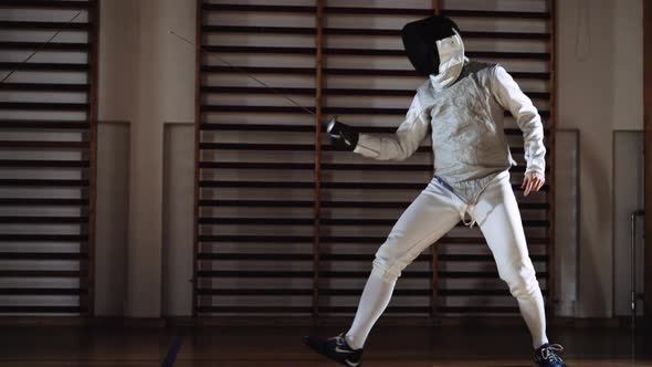 Men In Fencing Gear And Mask Duelling With Foils