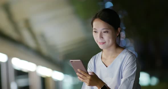 Woman work on cellphone at night