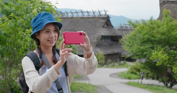 Woman use of mobile phone to take photo in Japanese wooden house 