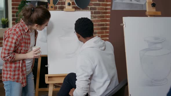 Young Woman Explaining Artistic Lesson to Student in Art Class