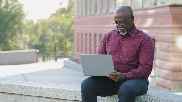 Serious Focused Senior Black Person Using Laptop African American Mature Male Communicating on