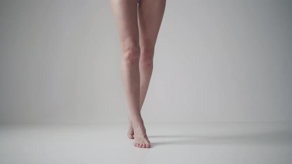 Slender Female Legs - Girl Goes To the Camera on Tiptoes on a Light Background