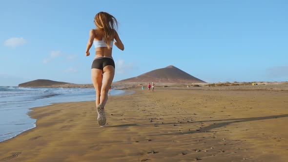 Woman Athlete Silhouette Running on Beach Sprinting Waves Crashing on Seaside Morning Background
