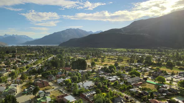 Aerial rising over Lago Puelo picturesque village with lake and Andean mountains in background at go