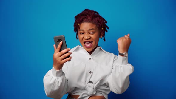 Successful Afro Woman Recieved Good News on Smartphone and Clenches Fist Achieved Her Goal