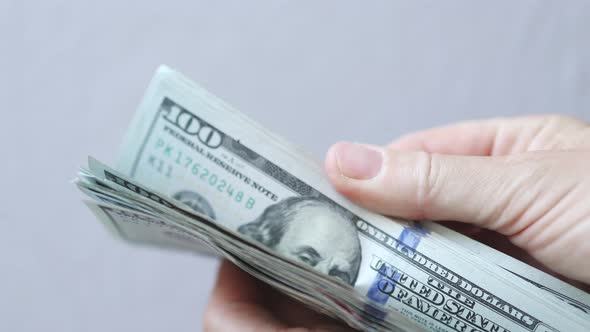 Shuffling Stack Pack of Hundred 100 Dollar Bills on Light Grey Background