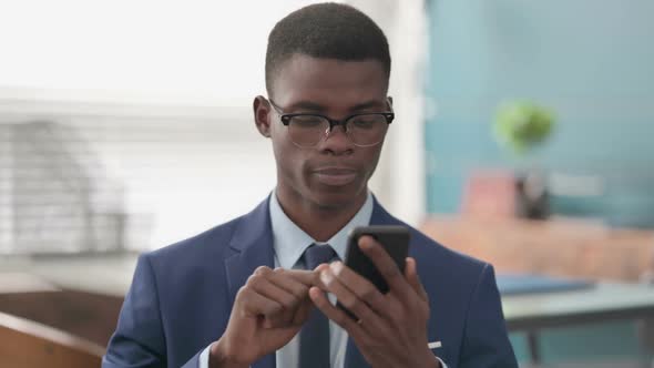 Young African Businessman Using Smartphone