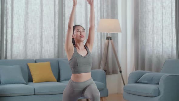 Young Asian Athletic Female In Sports Clothes Practicing Different Asana Poses On The Mat At Home