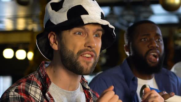 Male Friends With Soccer Hat and Vuvuzela Disappointed About Referee Decision