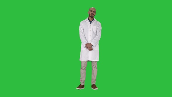 Standing young serious arab doctor on a Green Screen, Chroma Key.