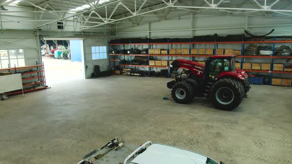 The Inside of a Massive Hangar with a Man Repairing a Tractor Agriculture