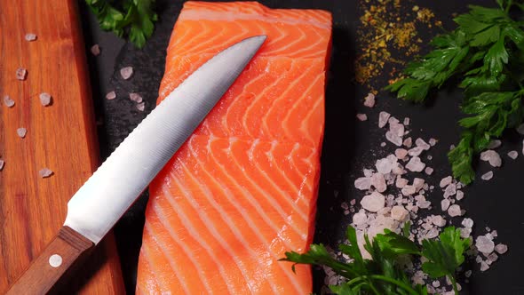 Delicious Fresh Salmon with Salt and Spices on a Black Stone Table