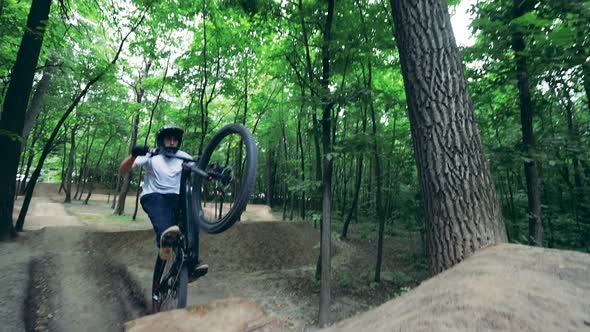A Man Is Doing Stunt Jumping on His Bmx in the Forest