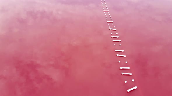 Old Pier on Pink Lake with Therapeutic Mud Ungraded on Sunset, Air Drone View