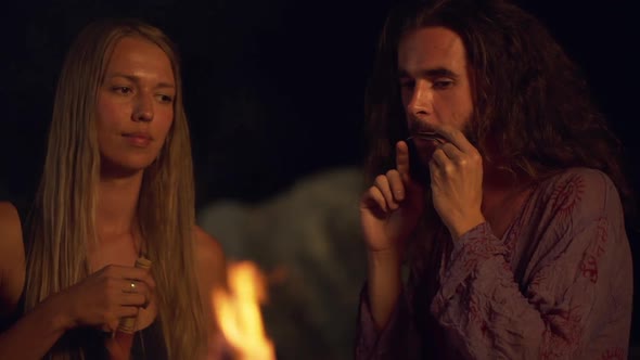 Friends Speaking Smiling Playing on Instruments Sitting Near Bonfire at Night Beach