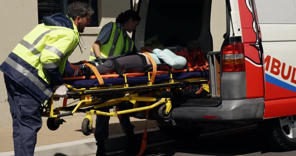 ambulance team carried the injured woman away on stretchers