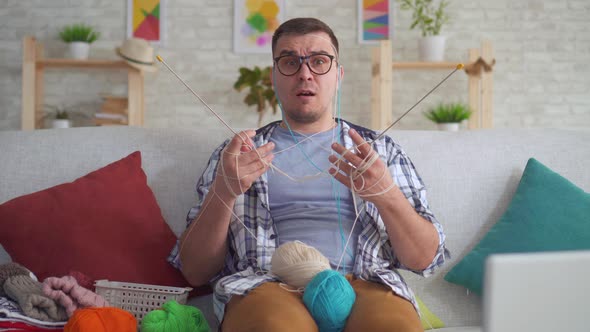 Clumsy Young Man with Glasses Knitting Needles