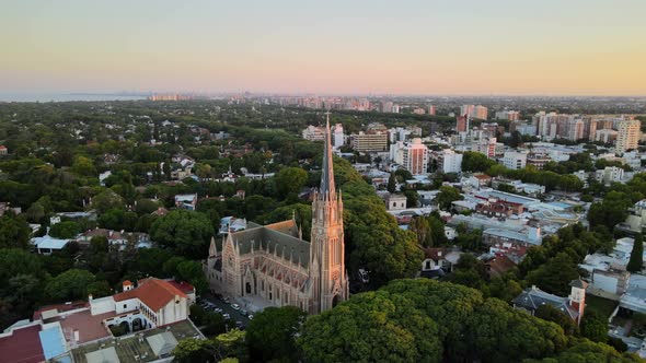 Aerial dolly out of San Isidro Cathedral and Buenos Aires city on background at sunset