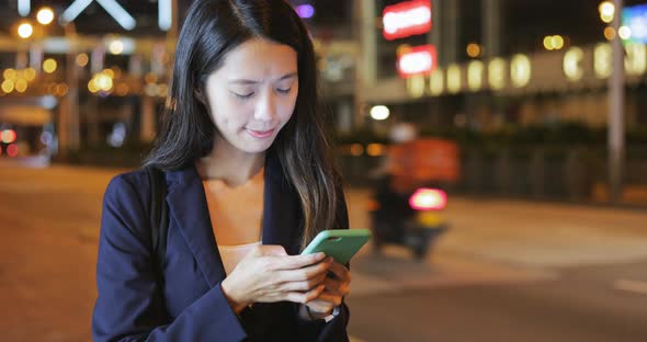 Businesswoman looking at mobile phone at night 