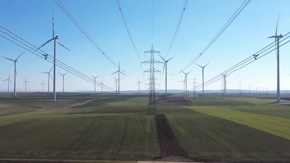Stream Mast Electricity With Wind Turbines In Green Meadows In Summertime. Aerial Drone Shot