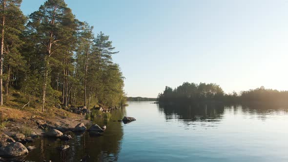 Kayaks at Bank of Large Lake Near Island with Pine Forest