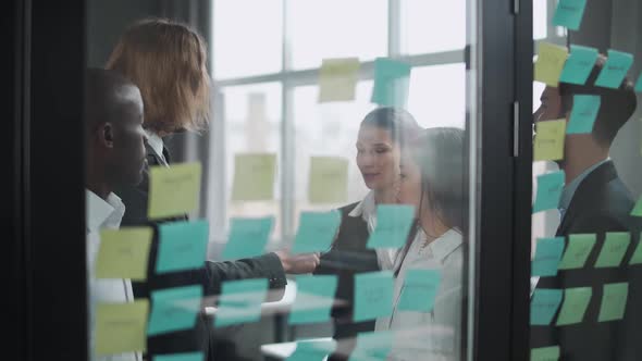 Business Meeting International Management Team at Work Team Is Standing Next To a Glass Board with