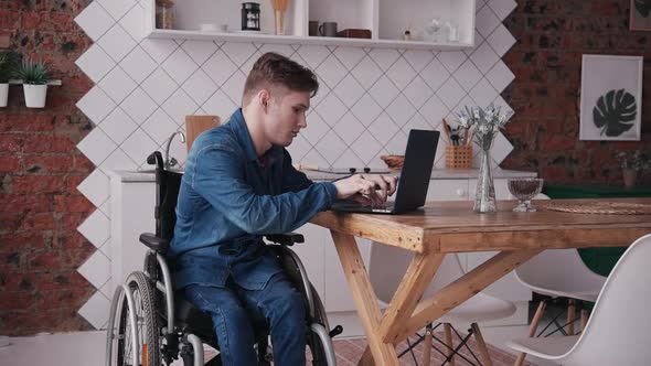 Young Man in Wheelchair Using His Modern Pc at Home