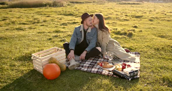 Young Man in a Hat with a Woman on a Picnic