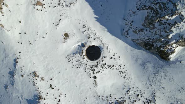 Aerial view of a well in the snowy mountains, Sierra de Serella, Alicante, Spain.