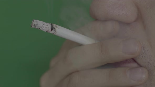 Cigarette in the Mouth of a Smoker. Close-up. Chroma Key. Green Background.