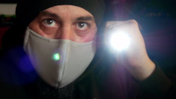 Male wearing virus mask checking infectious contamination with torch light