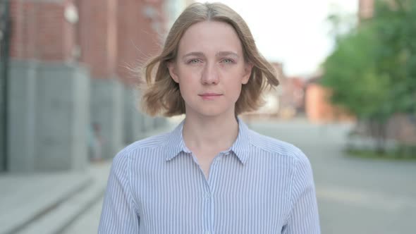 Portrait of Serious Woman Looking at the Camera Outdoor