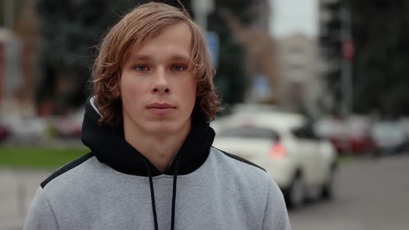 Slow Motion Video Portrait of Young Man Looks at a Camera in the City