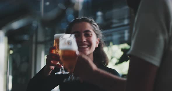 Barman serving two crafted lager beer to two friends in a modern urban bar