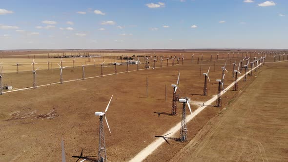 Aerial View of Wind Turbines Generating Clean Wind Power Among Yellow Fields. Renewable Energy