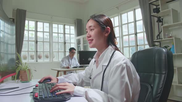 Young Asian Woman Doctor Is Using Computer In Workplace. Medical Concept