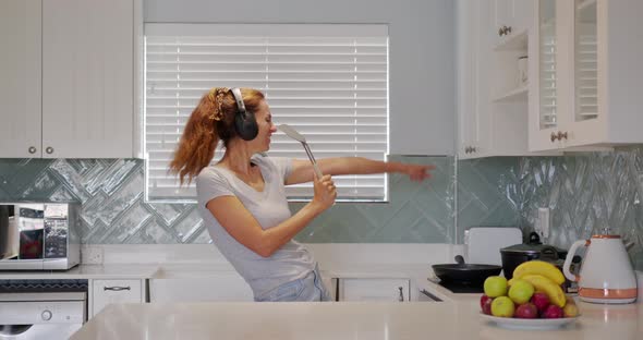 Portrait of Cheerful Woman Singing Song in Whisker on Dometic Kitchen in Slow Motion