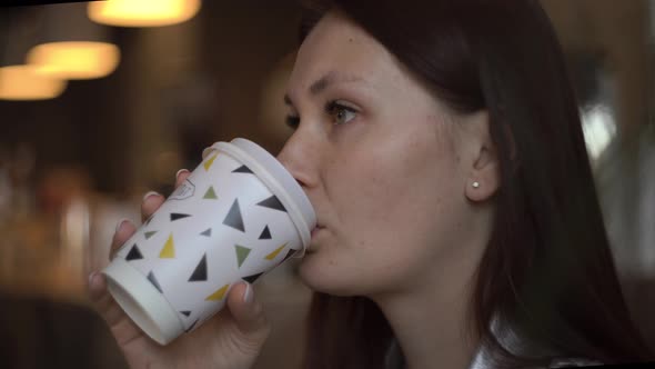 Woman Drinking Coffee in a Cafe While Waiting for a Meeting with a Partner