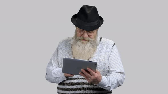 Old Retired Grandpa Surfing the Internet Using Tablet Pc