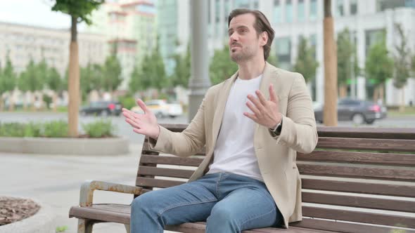 Tense Young Man Feeling Frustrated While Sitting on Bench