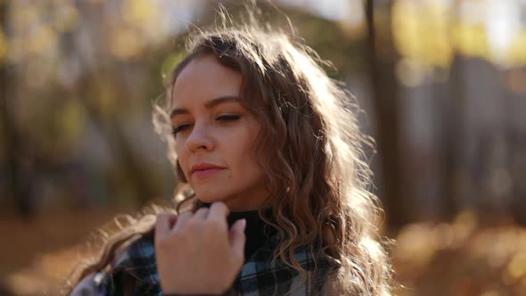 Portrait of a Woman with Curly Hair and a Plaid Coat on a Sunny Day