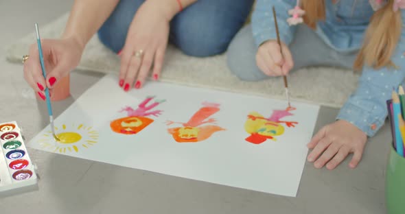 Hands of Mother and Daughter Painting on Floor