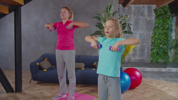 Mother and Child Doing Dumbbell Upright Row Indoors