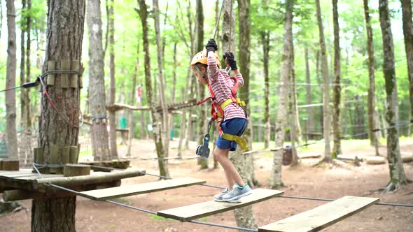 Boy Comes to the Wooden Platform From the Agility Bridge