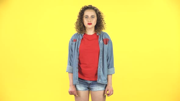 Scared Girl with Wow Face Expression on Yellow Background at Studio.