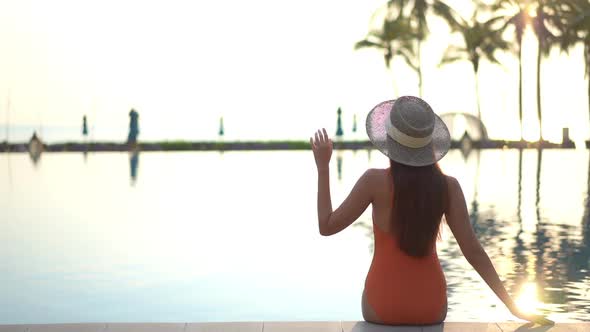 Young asian woman enjoy around outdoor swimming pool for leisure