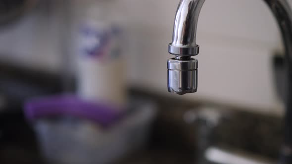 Leaking faucet kitchen close-up in slow motion